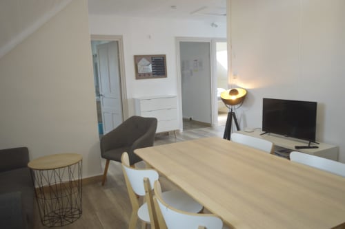 Séjour contemporain à la Résidence des dunes de Landéda avec table à manger, téléviseur et mobilier design
