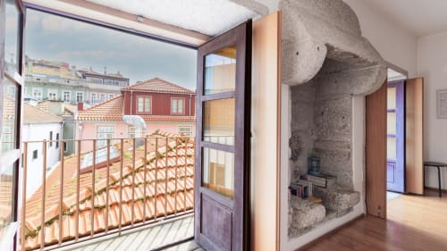 Lumineux appartement de Porto avec balcon surplombant des édifices colorés, intérieur moderne aux parquets bois et pierre