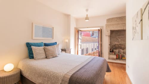 Bright bedroom at Flowerstreet54 in Porto with queen bed, balcony access, wooden floors, and city views