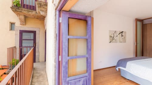 Chambre d'appartement moderne à Porto avec porte violette, parquets et accès balcon à Flowerstreet54