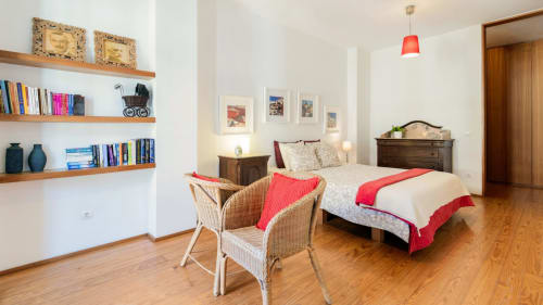 Chambre spacieuse romantique à Porto avec étagères en bois, accents rouges et vue sur la ville au Flowerstreet54