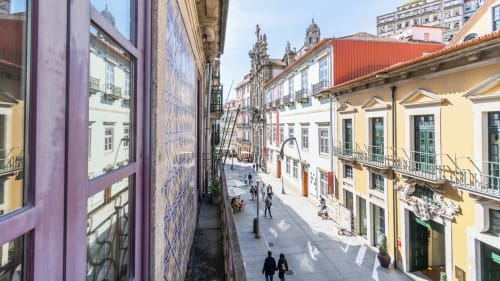 Ruelle pavée étroite du centre historique de Porto avec ses bâtiments colorés et le clocher de l'église