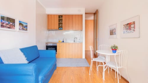 Appartement moderne à Porto avec canapé bleu, cuisine en bois et table à manger blanche près de la gare et du métro