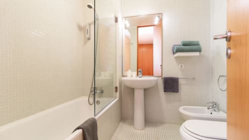 Salle de bain moderne dans un appartement portuais avec douche, lavabo sur colonne et carrelage blanc à Flowerstreet54