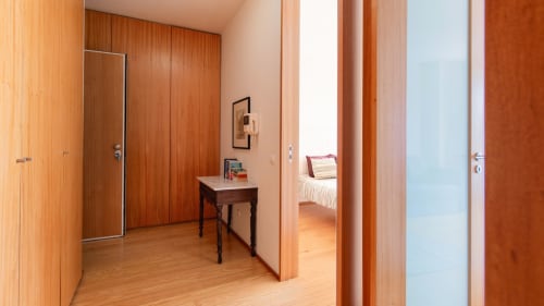 Couloir moderne de l'appartement à Porto avec portes en bois, petit bureau et vue sur la chambre, propriété Flowerstreet54