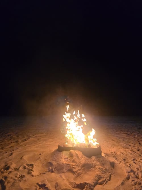 Feu de camp en bord de mer sur le sable à Tikehau Herearii, Tuherahera, Polynésie française