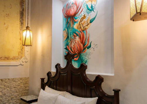 Elegant bedroom at Villa Merida Boutique Hotel with ornate dark wood headboard and colorful floral mural above bed in Merida,