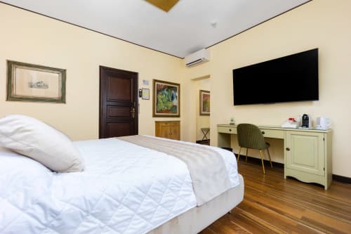 Lussuosa camera da letto presso Reggio Suite B&B a Reggio Calabria con letto bianco, pavimenti in legno e servizi moderni