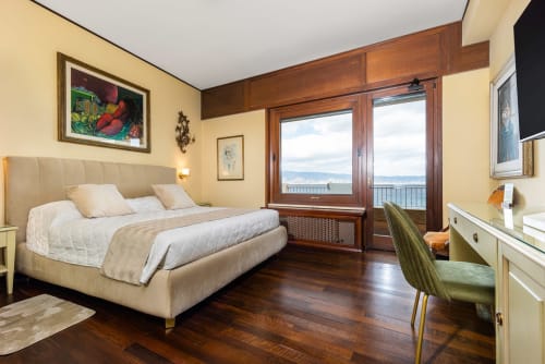 Lussuosa camera da letto presso Reggio Suite B&B a Reggio Calabria con balcone vista mare, arredamento in legno e design contemporaneo