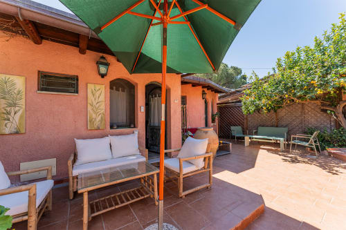 Area lounge in terracotta sotto ombrellone verde presso Guest House Villa Verde, Torre delle Stelle