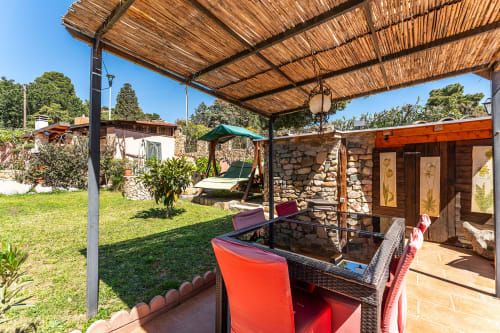 Vista giardino della terrazza di Villa Verde a Torre delle Stelle con tavolo da pranzo, pergolato e edifici in pietra