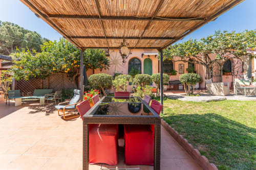 Patio ombreggiato della casa vacanze Villa Verde con lettini, piante in vaso e architettura mediterranea rustica