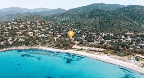 Vista aerea della spiaggia turchese con sabbia bianca, case in collina e montagne vicino alla guest house Villa Verde a Torre delle