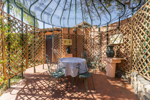 Patio coperto di Villa Verde con tavolo da pranzo, pareti a traliccio e pavimento in cotto a Maracalagonis
