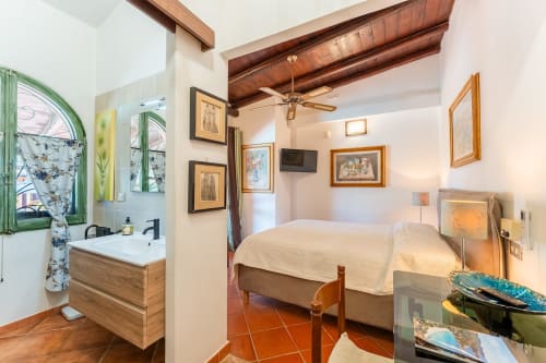 Camera confortevole con bagno privato presso la Villa Verde a Maracalagonis, con piastrelle in terracotta e travi in legno