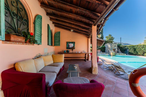 Patio coperto con zona relax con vista sulla piscina presso Villa Verde a Torre delle Stelle, Italia