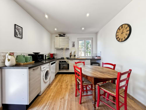 Cuisine moderne avec chaises rouges et table à manger en bois dans une villa de L'Île-Rousse