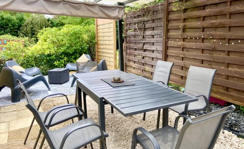 Terrasse de restauration extérieure du Gîte Ô Clair De Lune à Sarlat avec clôture en bois et mobilier de détente