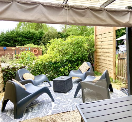 Terrasse ombragée avec mobilier contemporain à Ô Clair De Lune B&B à Sarlat, vue sur le jardin et espace détente extérieur.
