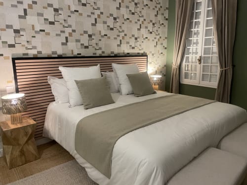 Chambre moderne à La Closerie B&B à La Redorte avec tête de lit rayée, literie neutre, carrelage géométrique et touches vertes