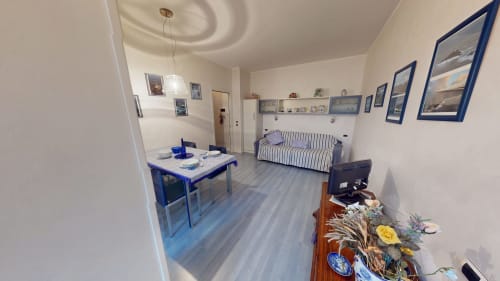 Marghera Home Apartment in Mailand mit Esstisch, gestreiftem Sofa und Holzböden