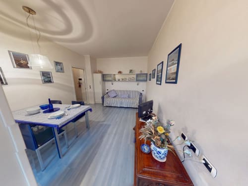 Marghera Home Apartment in Milano mit Esstisch, gestreiftem Schlafsofa und blauem Mobiliar