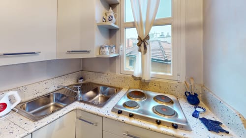 Moderne Küche im Marghera Home Apartment in Milano mit Edelstahlspüle, Induktionskochfeld und Stadtblick vom Fenster