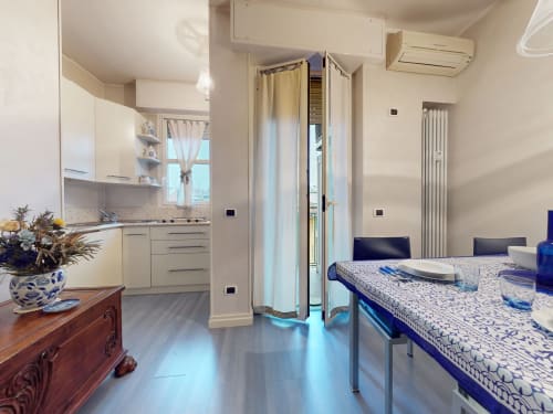 Moderne Mailänder Apartment-Küche und Essbereich mit Stadtblick, weiße Möbel, Induktionskochfeld und Esstisch bei Come