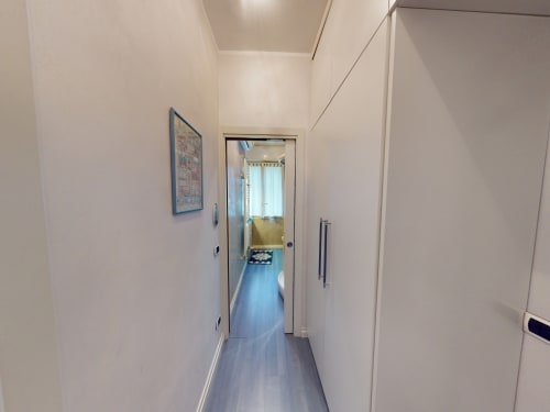 Moderner Flur im Marghera Home Apartment in Milano mit weißen Wänden, dunklem Boden und Zugang zu Wohnbereichen