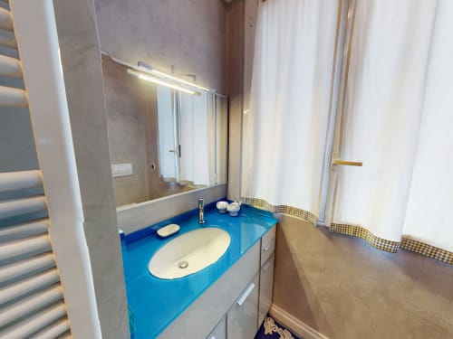 Modernes Badezimmer im Marghera Home, Mailänder Apartment mit blauem Waschtisch, weißem Waschbecken und großem Spiegel mit Beleuchtung