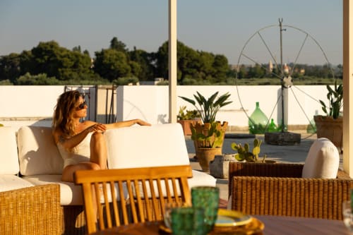 Donna che si rilassa sulla terrazza panoramica di Villa Ceci ad Andria, Italia, circondata da piante in vaso e viste sulla campagna