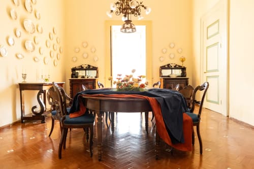 Elegante sala da pranzo di Villa Ceci ad Andria con tavolo rotondo, sedie in legno e pareti gialle
