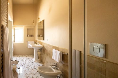 Bagno elegante di Villa Ceci B&B ad Andria, Italia, con lavandini su colonna, dettagli in piastrelle e finiture moderne