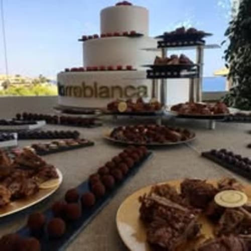 Elegante pastel de boda en capas con postres de chocolate y fresas frescas exhibidos en el hotel Finca La Cuevona de Guitiriz