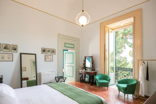 Camera Cristina King Deluxe a Villa Ceci ad Andria con poltroncine in velluto verde, vista sul giardino e arredi d'epoca