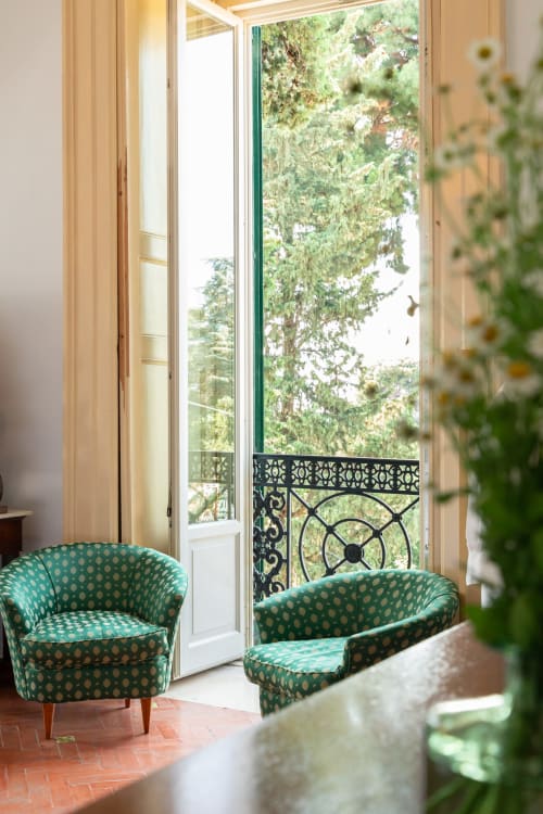 Elegante camera a Villa Ceci ad Andria con sedie turchesi decorate che si affacciano su un lussureggiante giardino attraverso porte-finestre