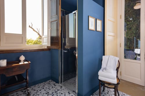 Bagno moderno blu con doccia in vetro, arredamento in legno e vista sul giardino di Villa Ceci Andria