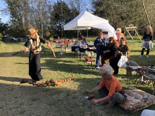 Outdoor gathering at Le Lama Zébré in Penmarch with performer and guests under white tent