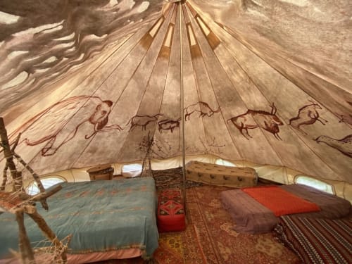 Nomadic tent interior at Le Lama Zébré with decorated canvas, bedding, and traditional rugs in Penmarch.