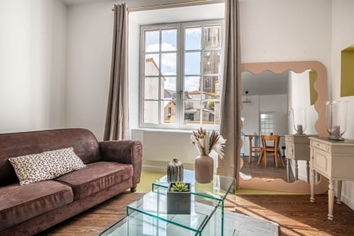 Élégant séjour de la Bise de la Jouvence B&B à Saint Laurent sur Sèvre avec canapé bordeaux et vue sur la ville