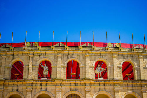Façade historique en pierre de la Maison d'hôtes Bise de la Jouvence à Saint Laurent sur Sèvre avec fenêtres cintrées rouges et toit ornemental