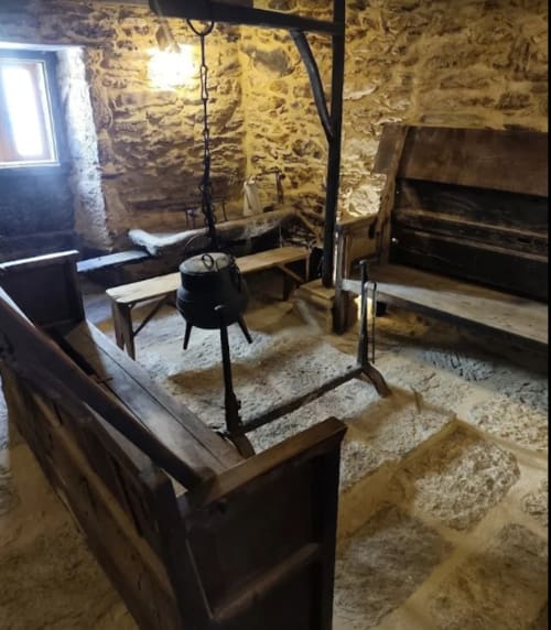 Cocina de piedra histórica en la casa rural O Trancallo en Mourisca, Ourense, con hogar de cocción tradicional