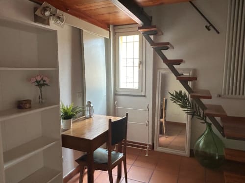 Loft Cento3Cento a L'Appartamento Giusto, Bologna: luminosa zona living con scale in legno e vista sulla città