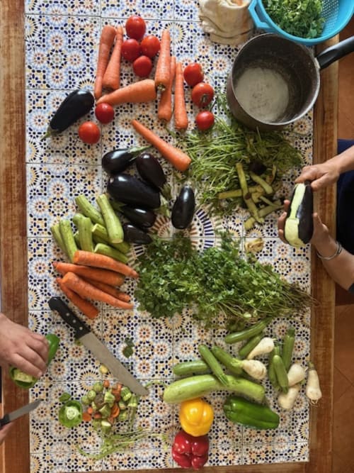 Légumes frais arrangés sur une mosaïque marocaine pour Tajine à Riad Eucalyptus: tomates, aubergines, carottes, concombres et herbes