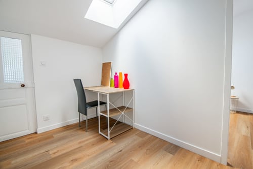 Chambre mansardée lumineuse à la Bise de la Jouvence avec bureau, chaise et puits de lumière à Saint Laurent sur Sèvre