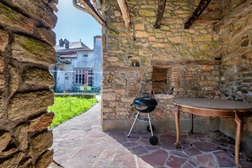 Cour de pierre du gîte Bise de la Jouvence à Saint Laurent sur Sèvre, avec barbecue et coin détente rustique