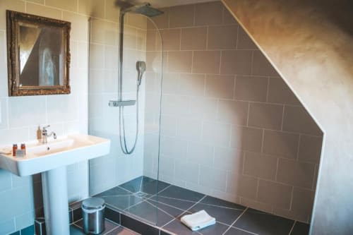 Salle de bains moderne au gîte La Girelle à Honfleur avec douche à l'italienne, lavabo colonne et plafond mansardé
