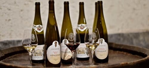 Bouteilles et verres de vin alsacien sur tonneau en bois à l'Hôtel de l'Ange, Niedermorschwihr