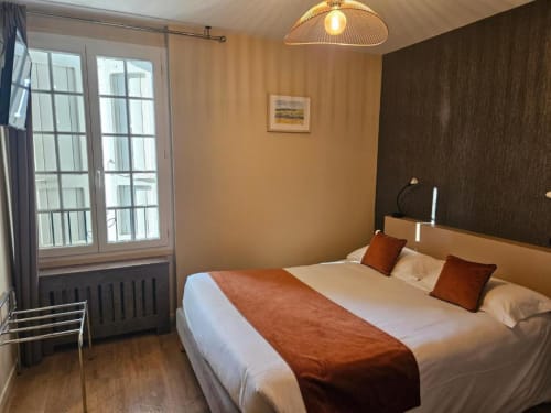 Chambre double standard à l'hôtel La Route d'Argent à Bozouls avec lit queen-size, mur d'accent sombre et vue sur balcon