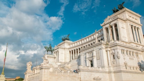 Maestoso edificio bianco in stile neoclassico con statue equestri sotto cielo azzurro vicino Campagnano di Roma